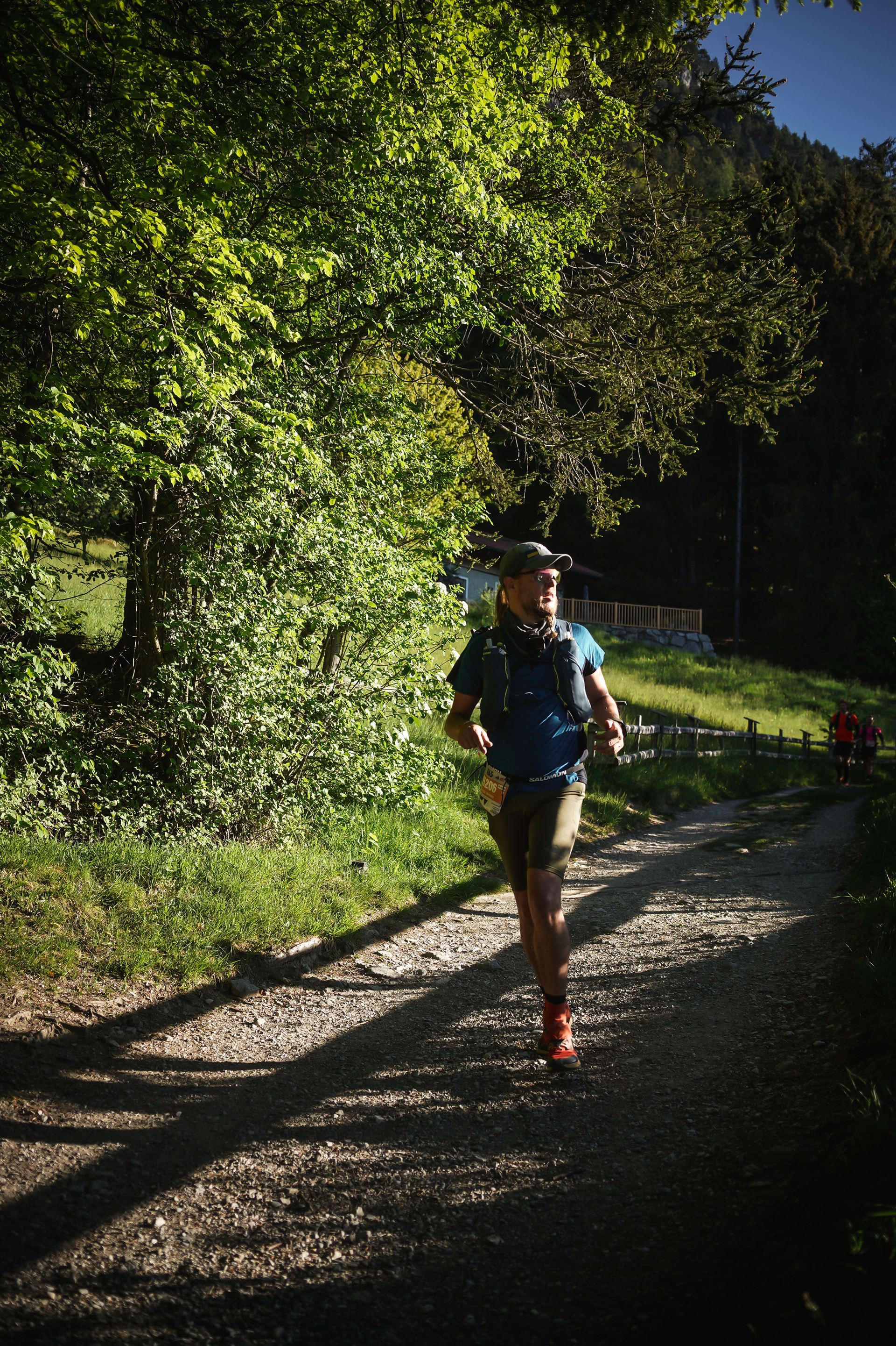 Juhani running a forest gravel road in low morning light