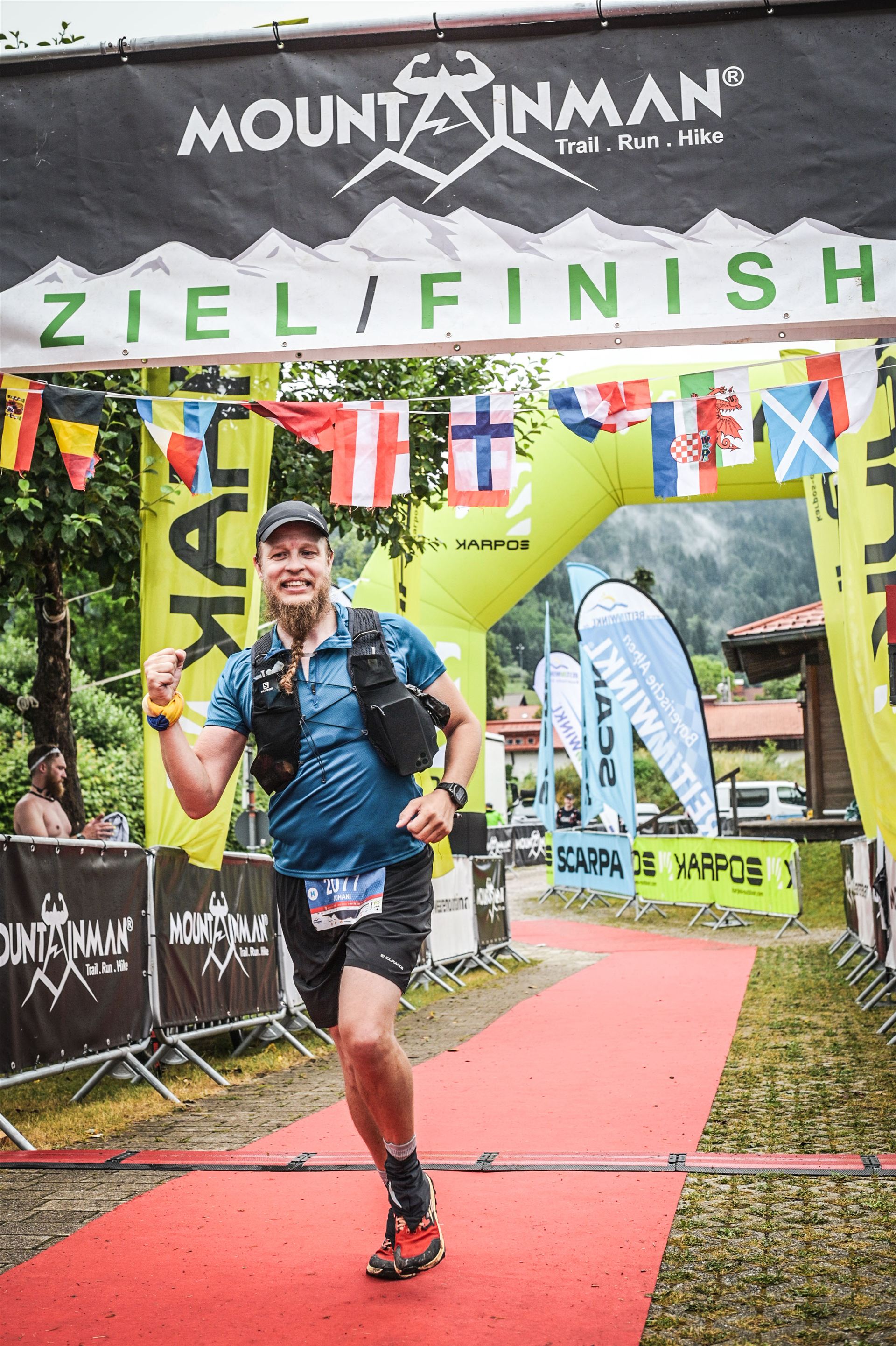 Juhani grinning across the Mountainman finish line, fist raised