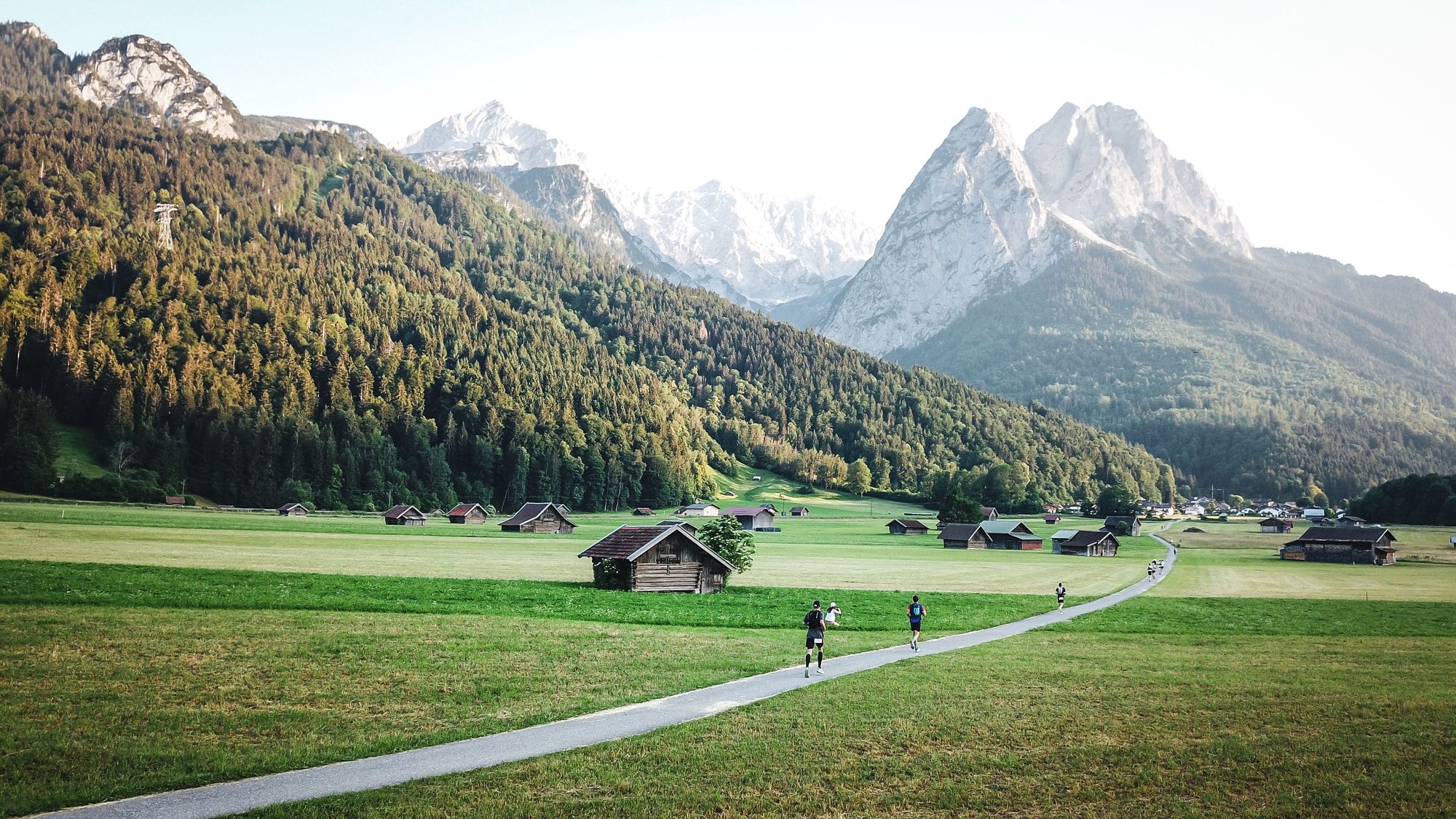 A trail leading through an alpine valley toward high peaks